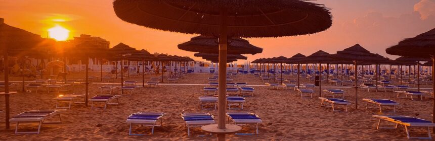 plaża w Italii o zachodzie słońca podczas podróży na wczasy w Rimini