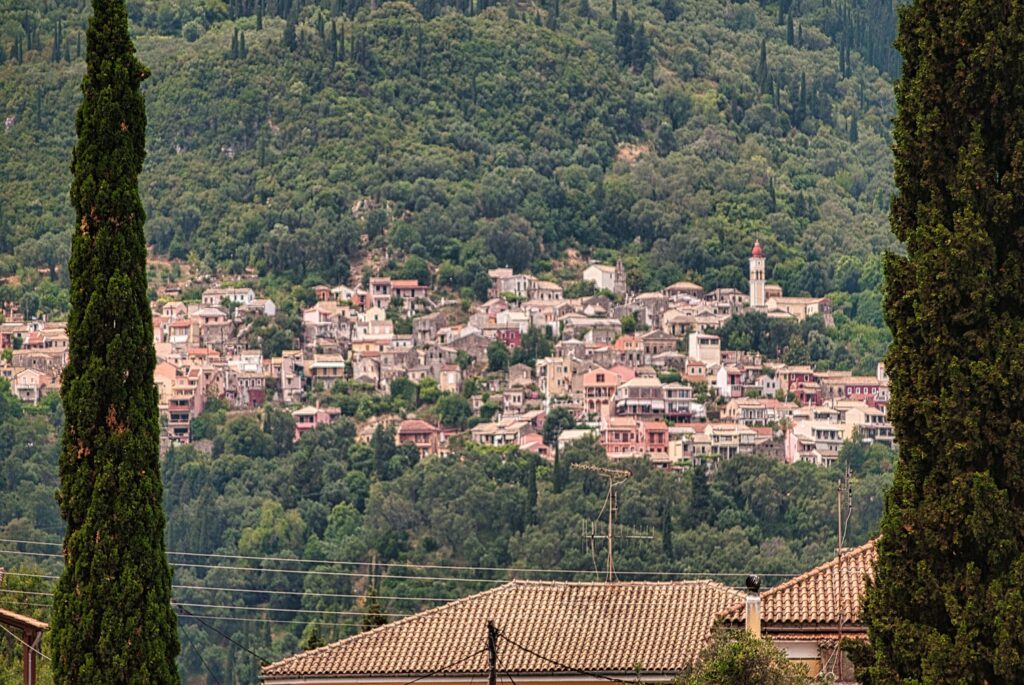 typowy dla Korfu krajobraz z malowniczym miasteczkiem na zboczu wzgórza